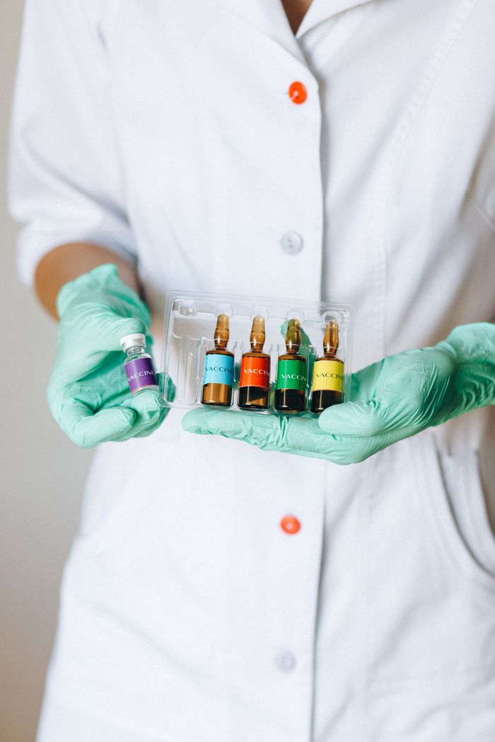category-05 Close-up of a nurse holding vibrant vaccine ampules in medical gloves for healthcare and medicine.